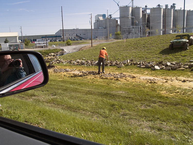 A Didion Ethanol worker rakes up the thick mash from a large spill along Highway 146